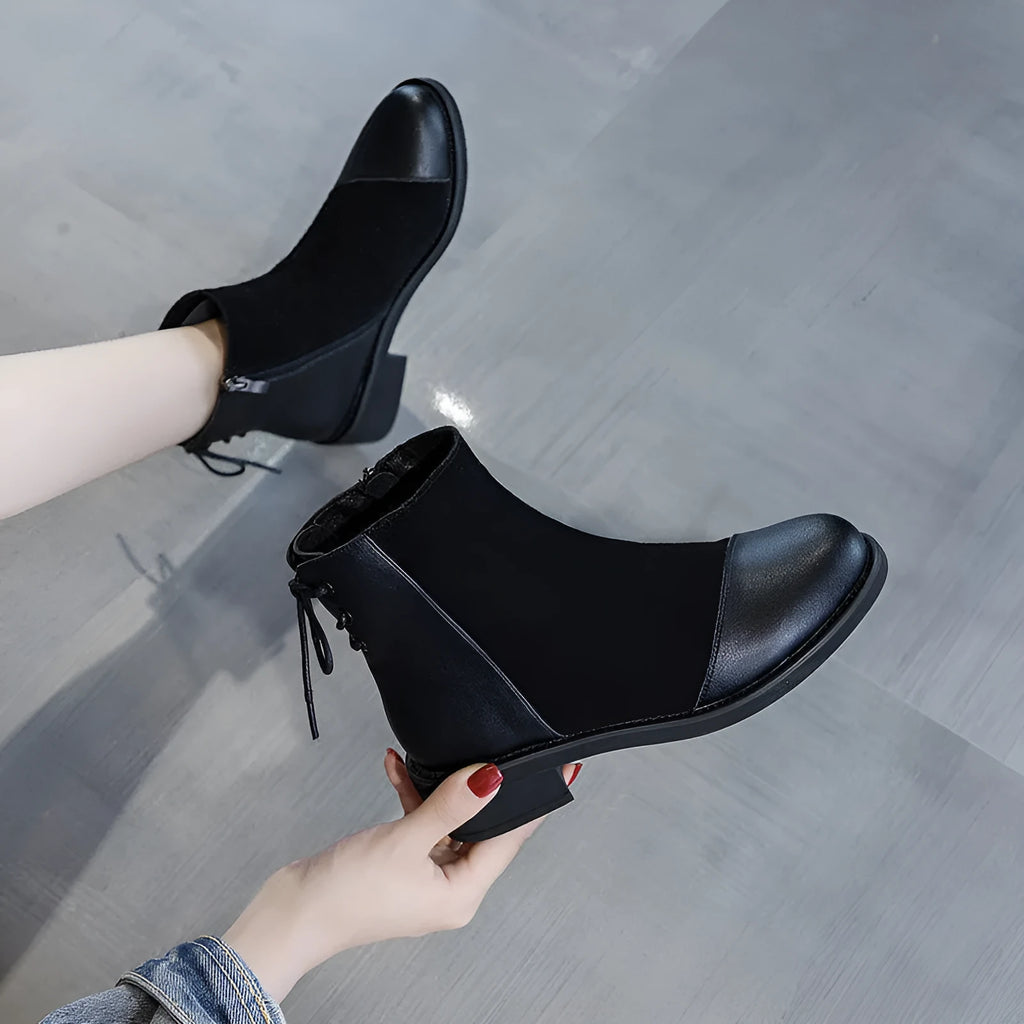 Black women's knee-high Martin boots with side zip and round toe on a short stout heel.