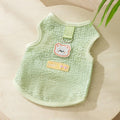 Green knitted cat clothing with a bear patch, showing hollowed-out breathable knit fabric.