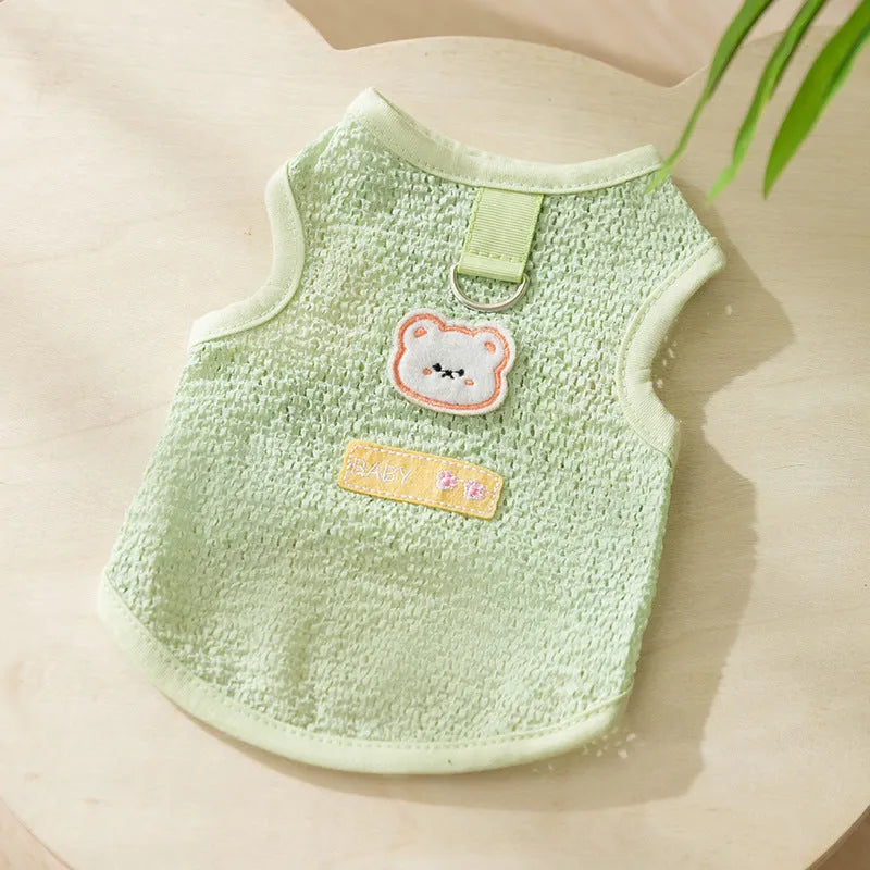 Green knitted cat clothing with a bear patch, showing hollowed-out breathable knit fabric.