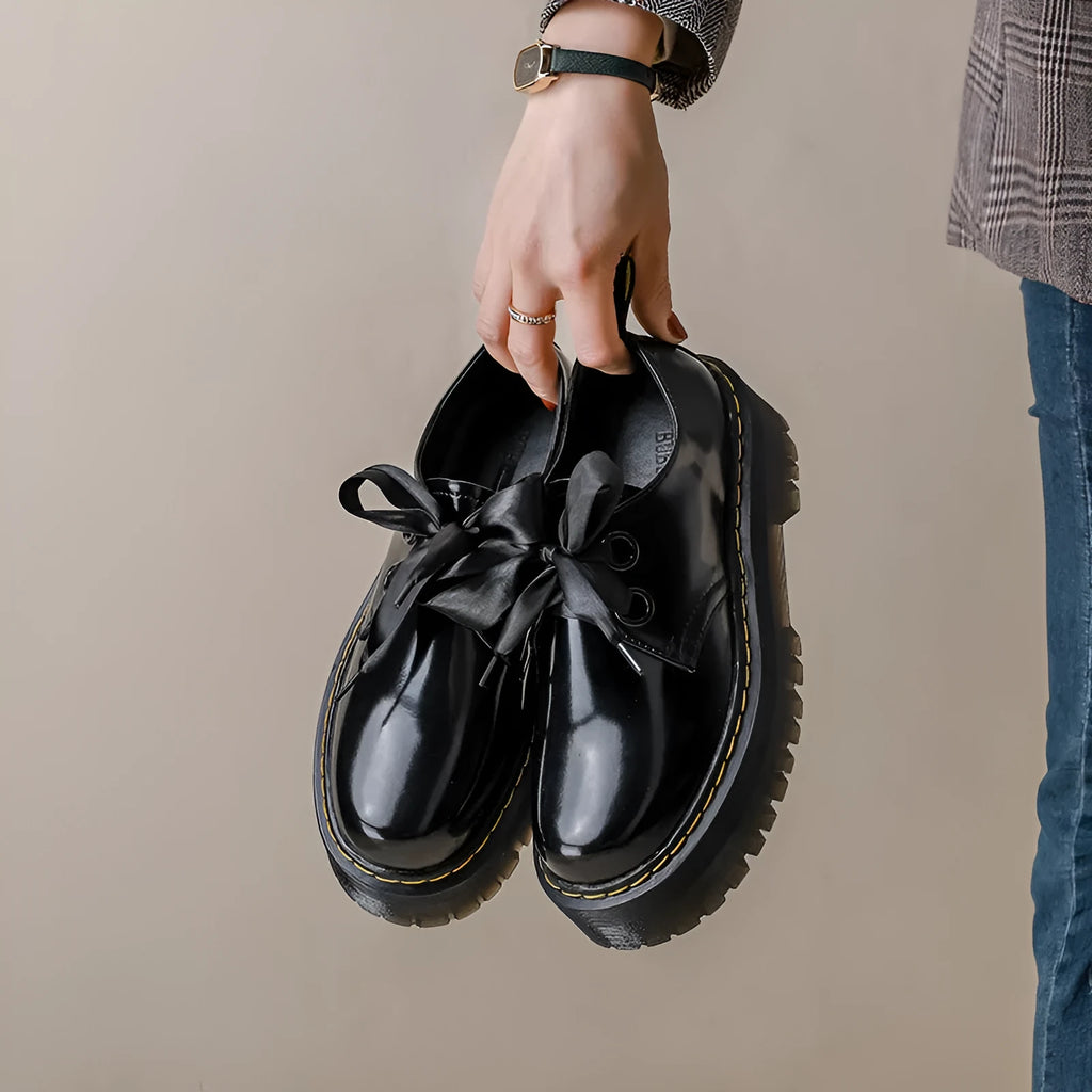Women's thick soled leather shoes with cross strap design and lace closure in black colour