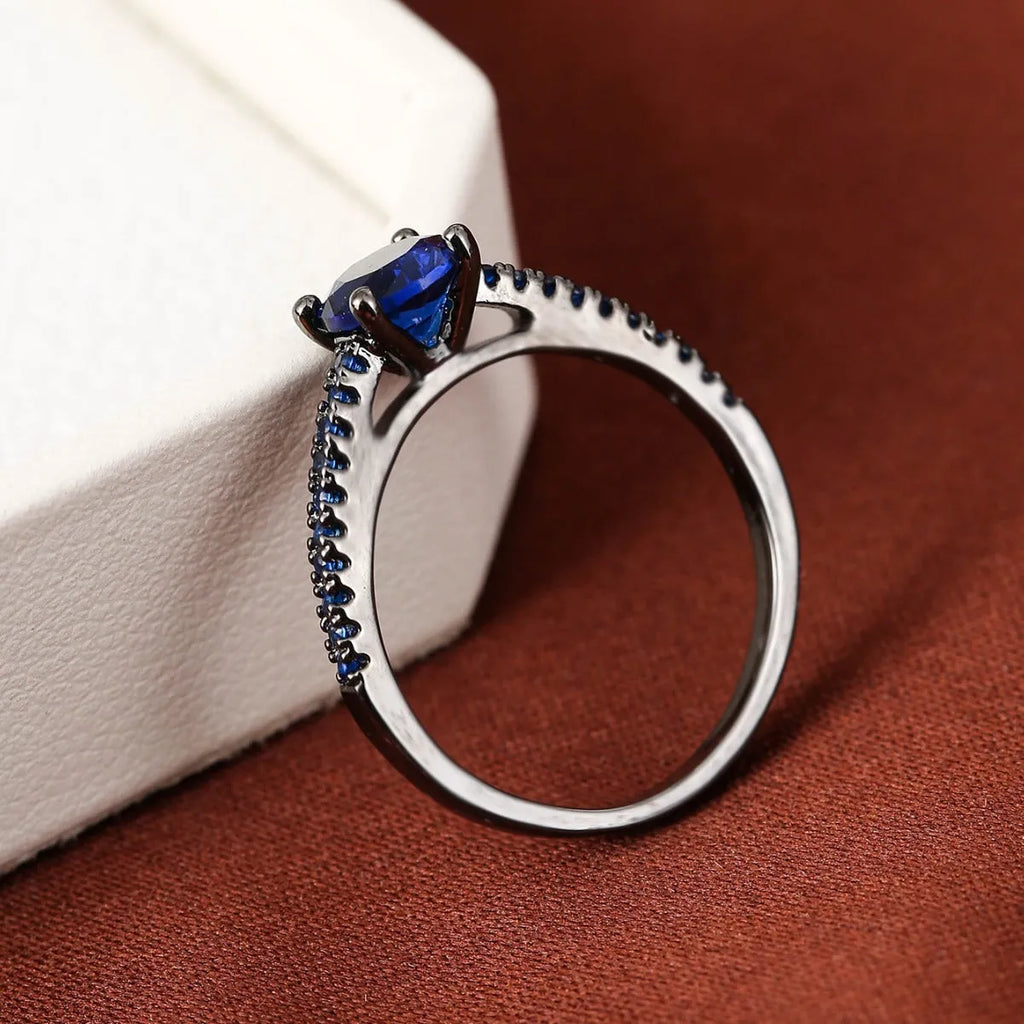 Hexagon geometric zircon ring on a finger, showing electroplated gold rose red colour and copper band.