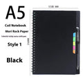 A5 erasable coil notebook with stone paper and pen on wooden surface