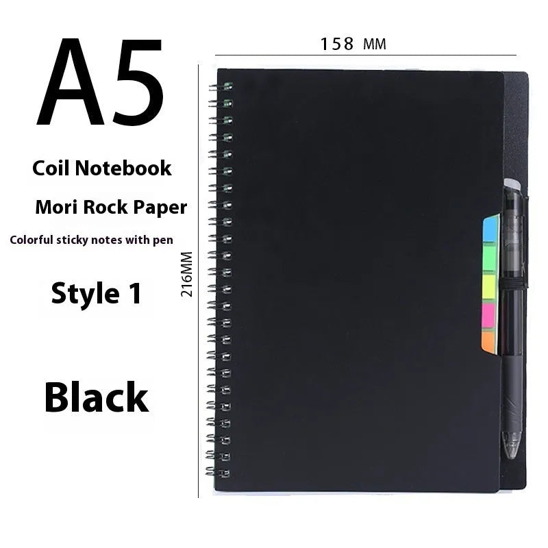 A5 erasable coil notebook with stone paper and pen on wooden surface