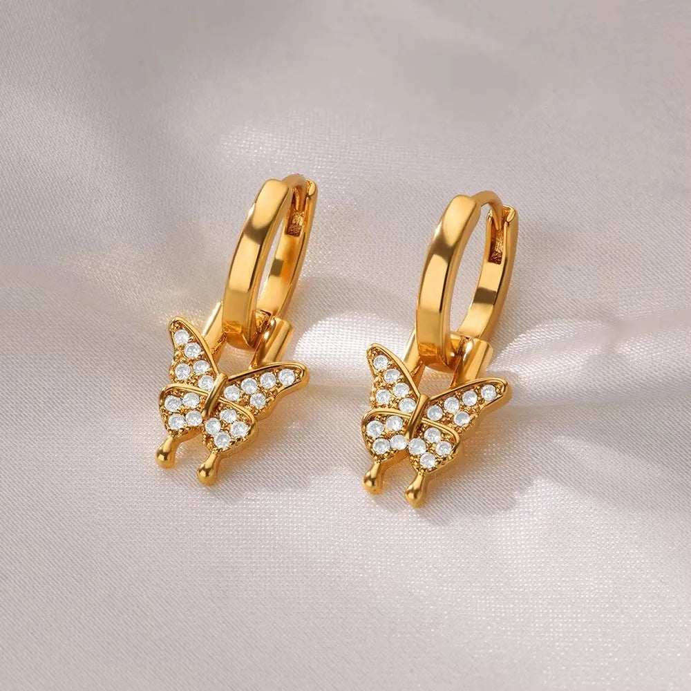 Geometric butterfly-shaped earrings with heart, bow, and star details in copper with a diamond-cut finish.