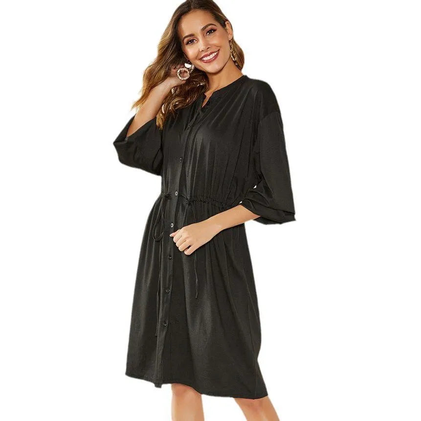 Black A-line midi dress with cinched belt and long sleeves on a mannequin
