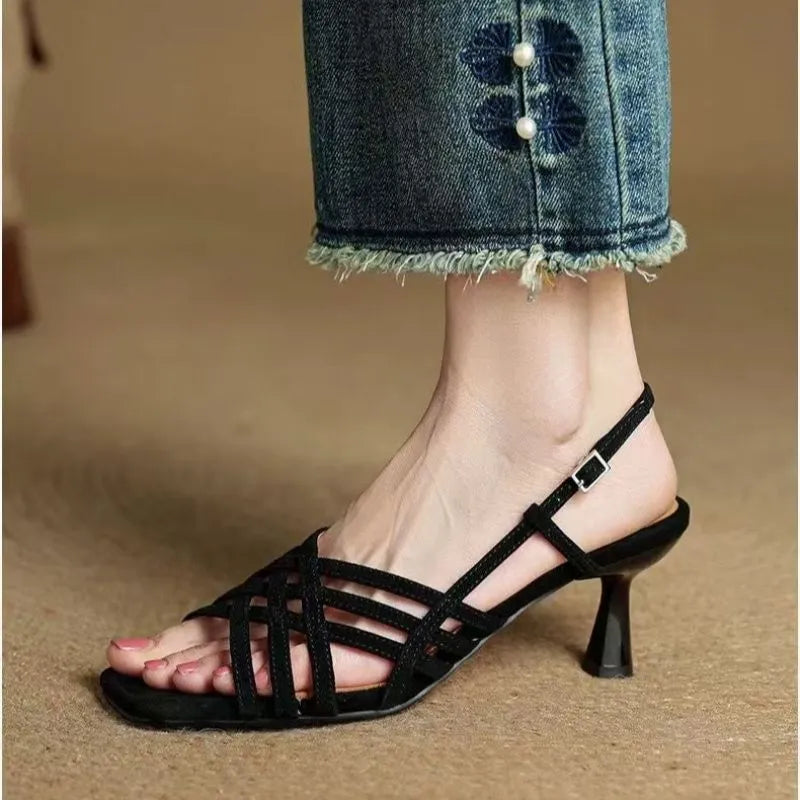 Retro women's sandals with thin cross straps, ankle buckle, and a mid heel on a square toe.