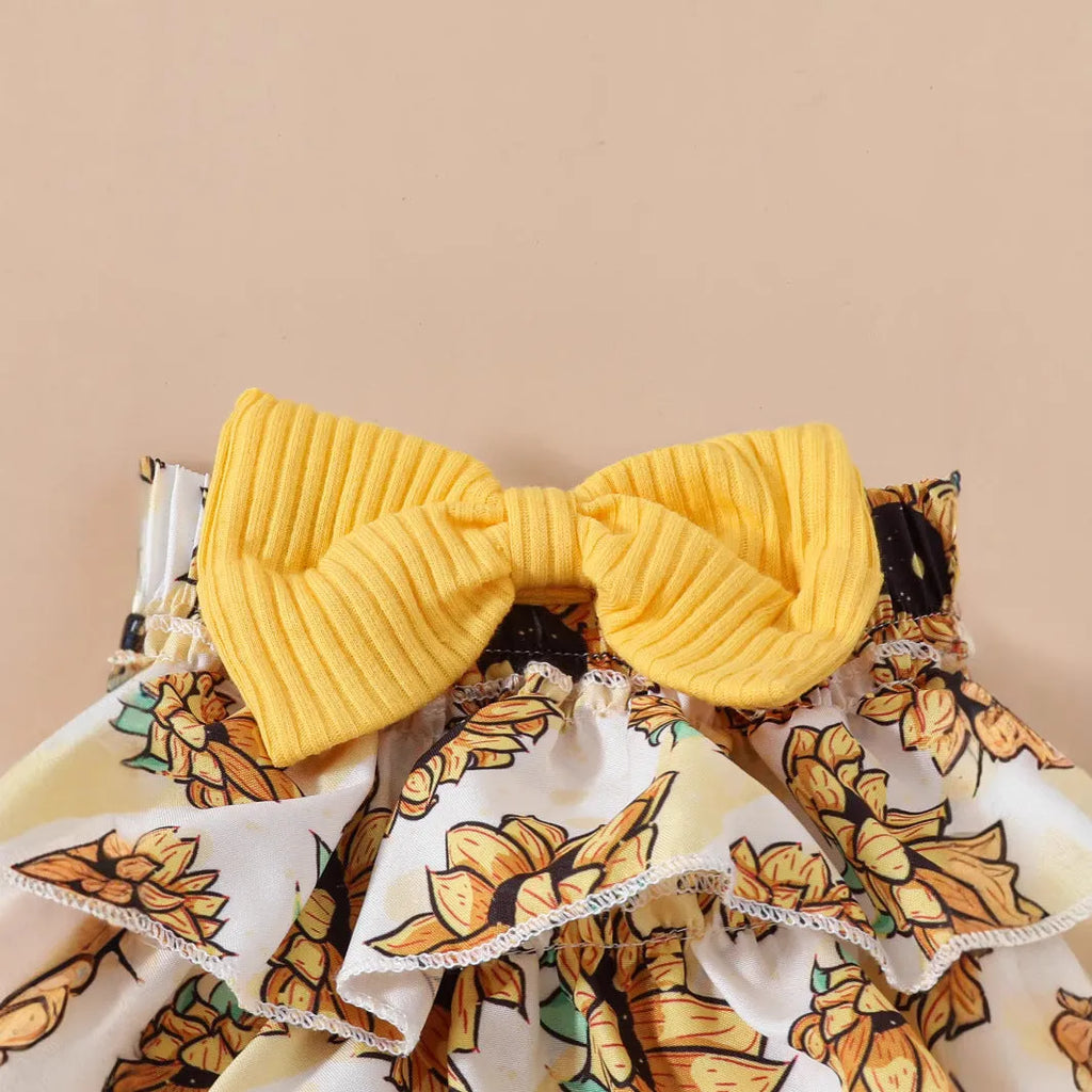 Baby girl yellow triangle ruffled shorts suit with white blouse and bow detail on baby model