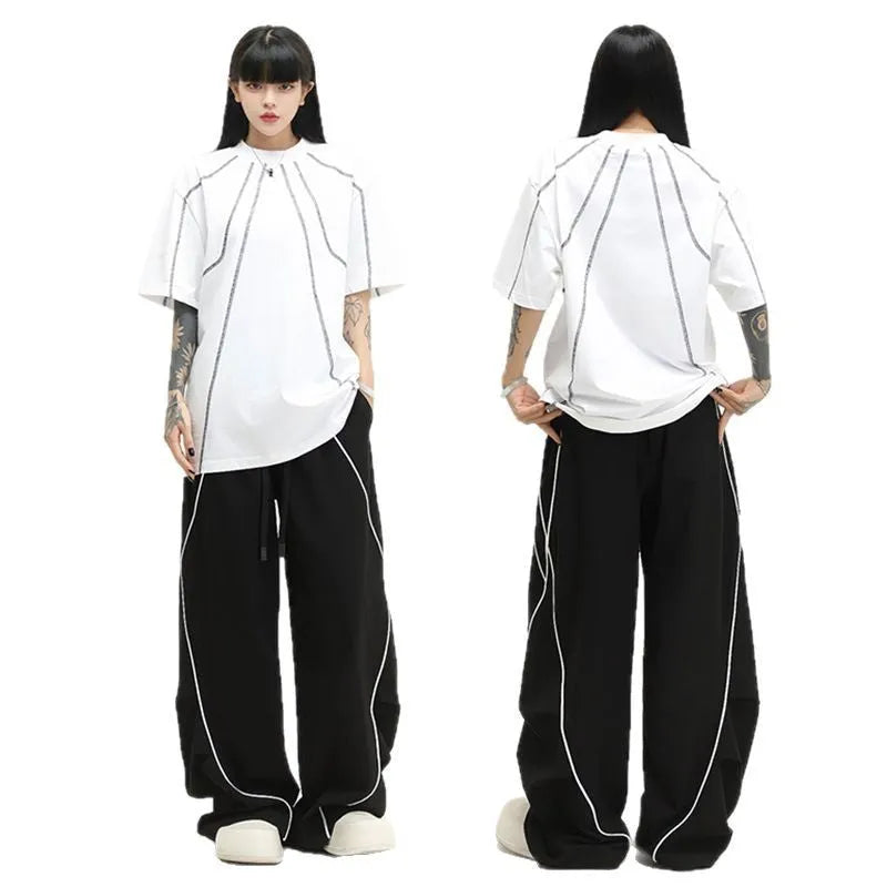 Black and white striped wide-leg hip hop sports trousers with pleats, shown laid flat.