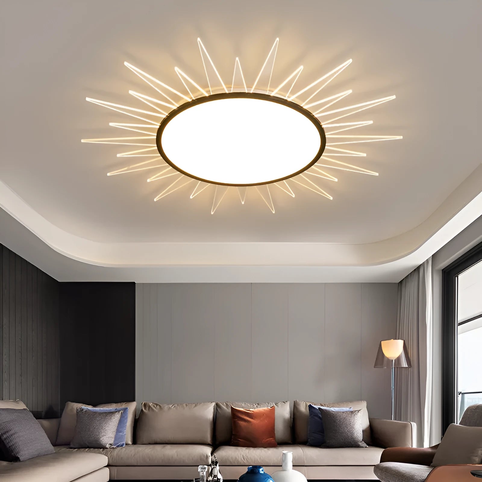 Modern round aluminium LED ceiling lamp with remote control shown in a living room setting.
