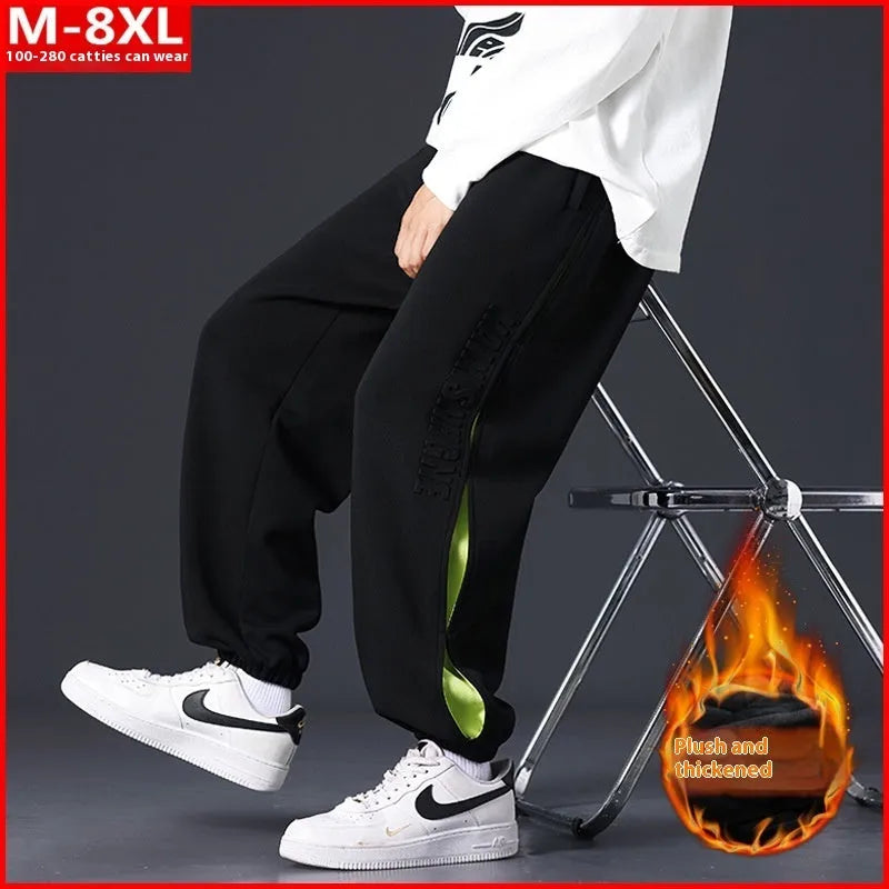 Men's loose grey green cotton trousers with ankle banding and stitching print detail on the leg.