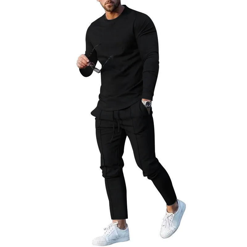 Man wearing a light grey round-neck long-sleeve t-shirt and matching trousers from a two-piece polyester suit set.