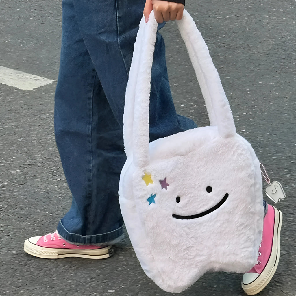 White plush large tooth shoulder tote bag with crossbody strap and zipper.