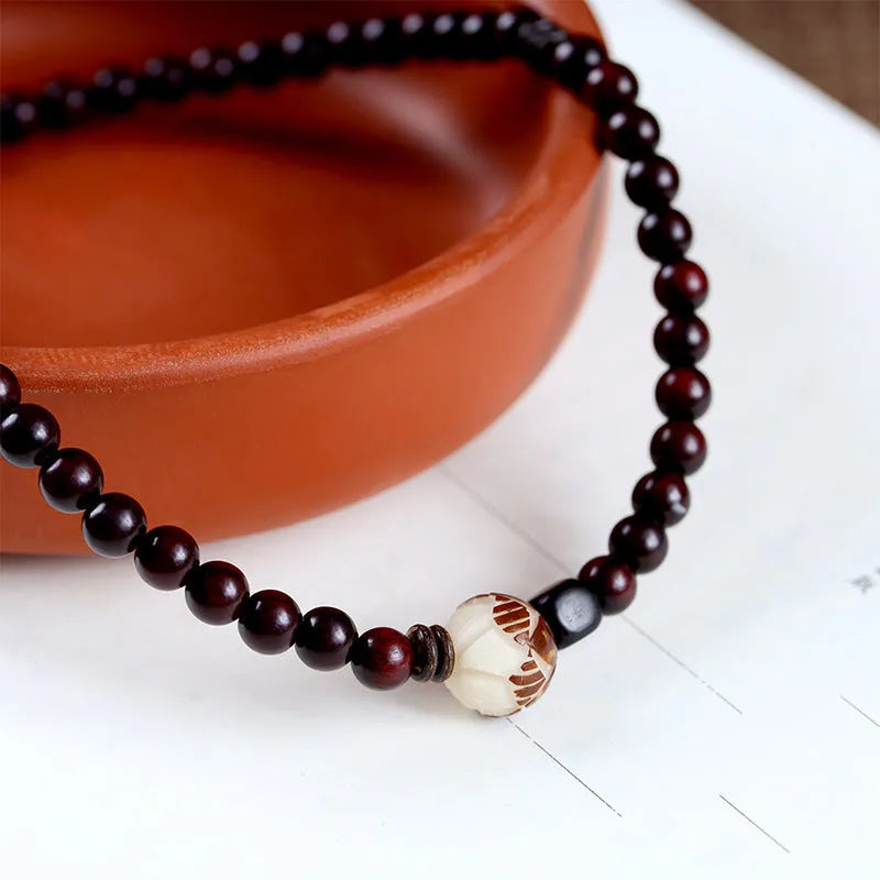 Rosewood bracelet with floral bead and knitted construction showing natural wood texture