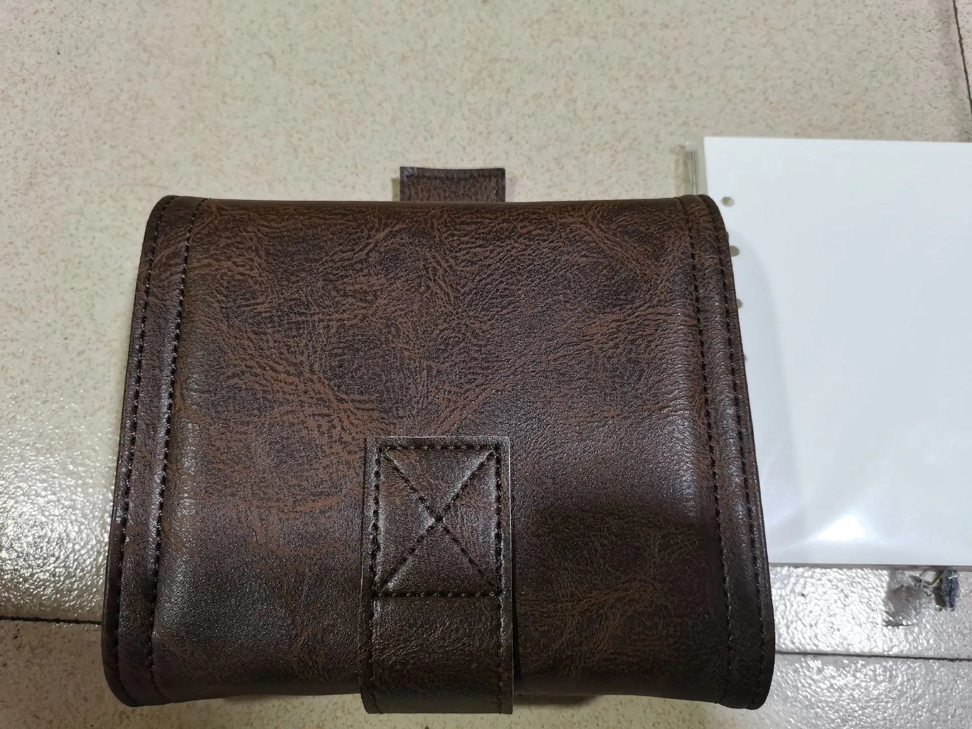 Brown retro notebook with buckle closure showing loose-leaf binding and A7 size