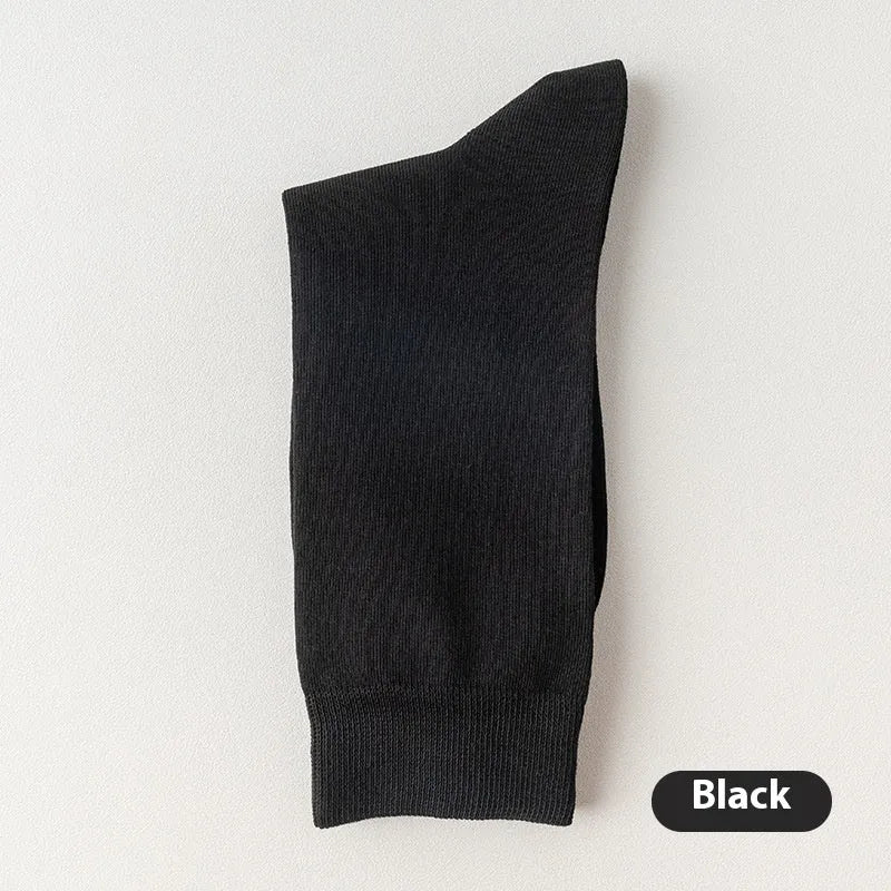 Mid-calf men's socks in solid colours made from combed cotton, shown in a stack.