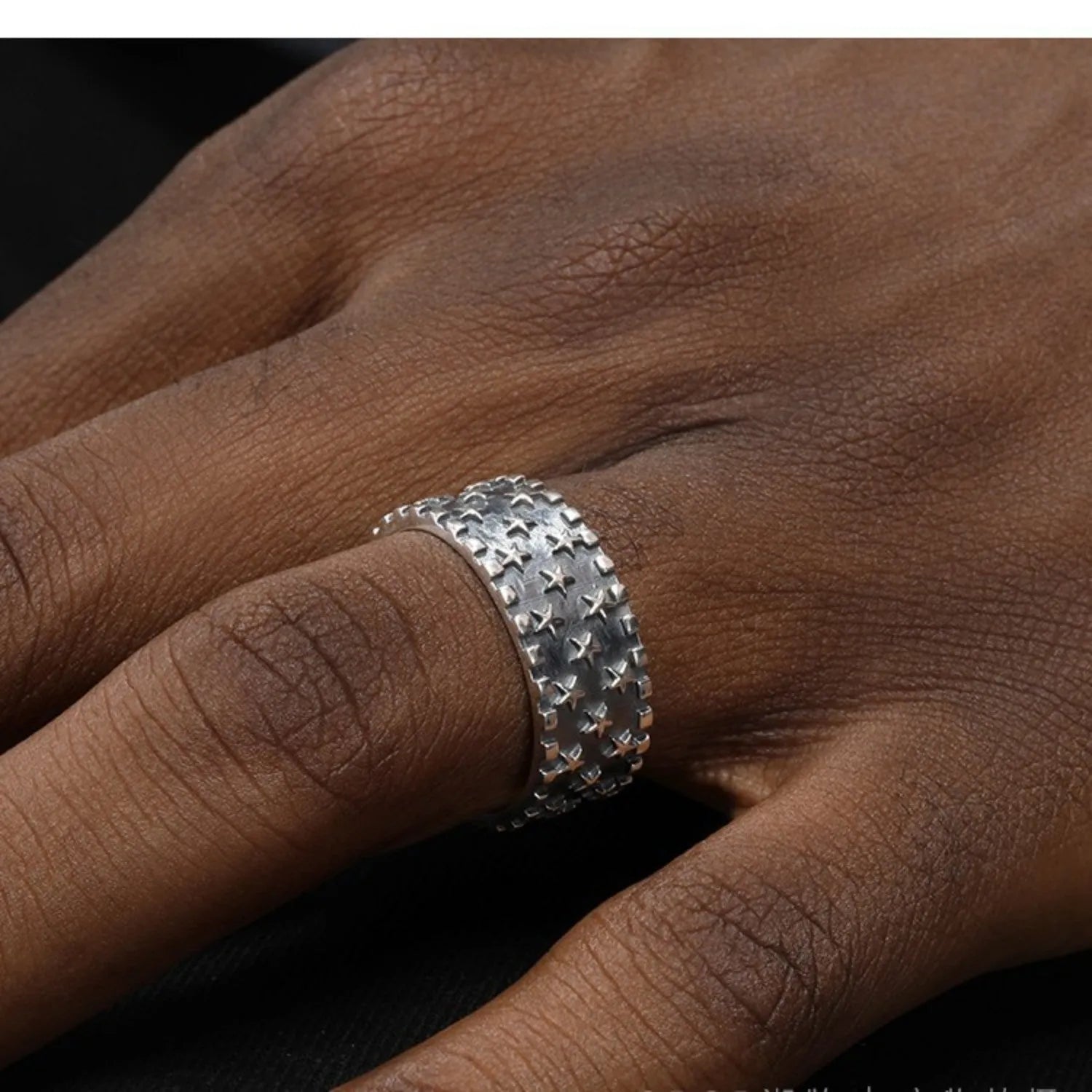 Close-up of a sterling silver ring with a geometric five-pointed star design on an adjustable band.