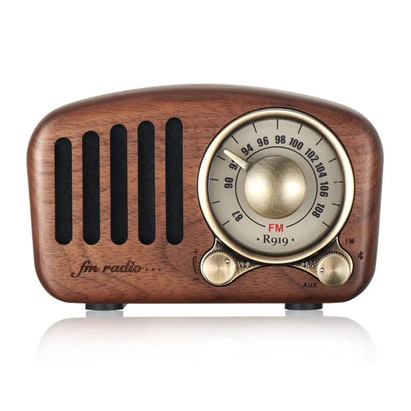 Compact retro wooden wireless Bluetooth speaker in cherry wood finish on a wooden table