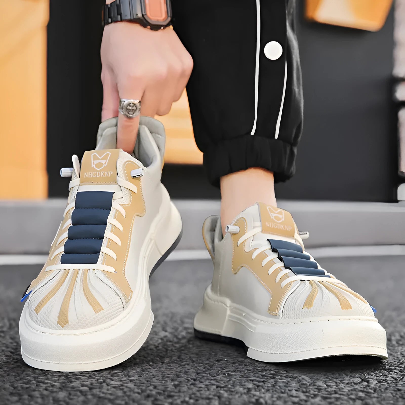 Men's beige low-top casual sneakers with elastic band and round toe, showing leather stitching detail.