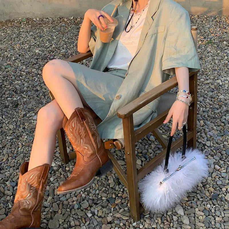 Brown women's embroidered mid-calf Martin boots with a round toe and low square heel.