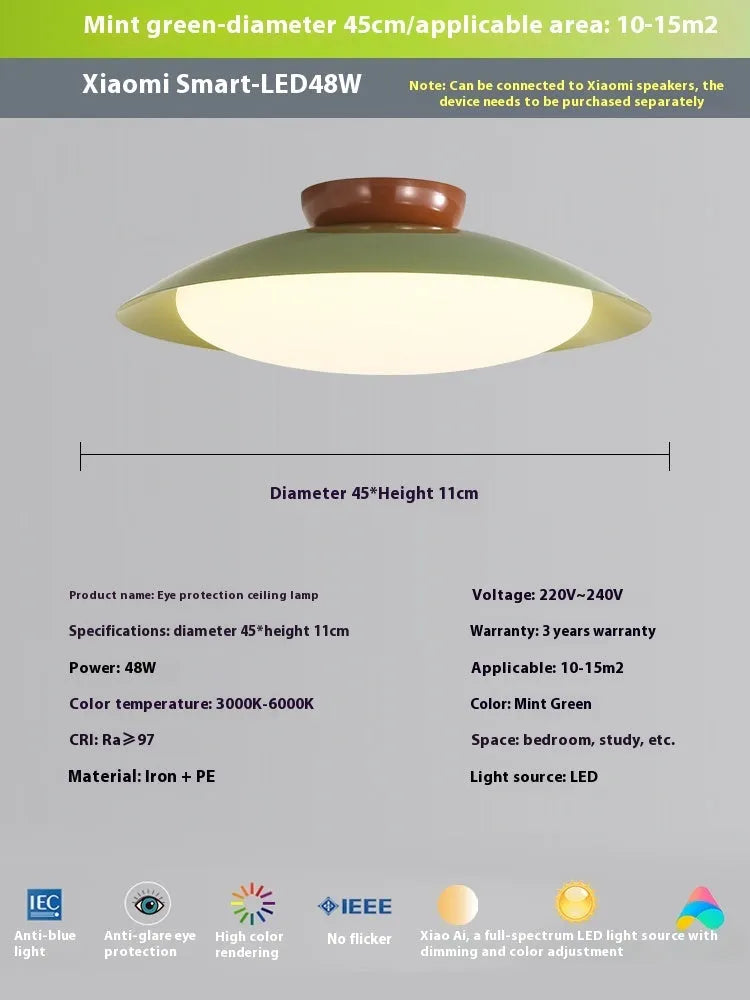 Modern minimalist flying saucer design ceiling lamp in cream yellow on a white ceiling.