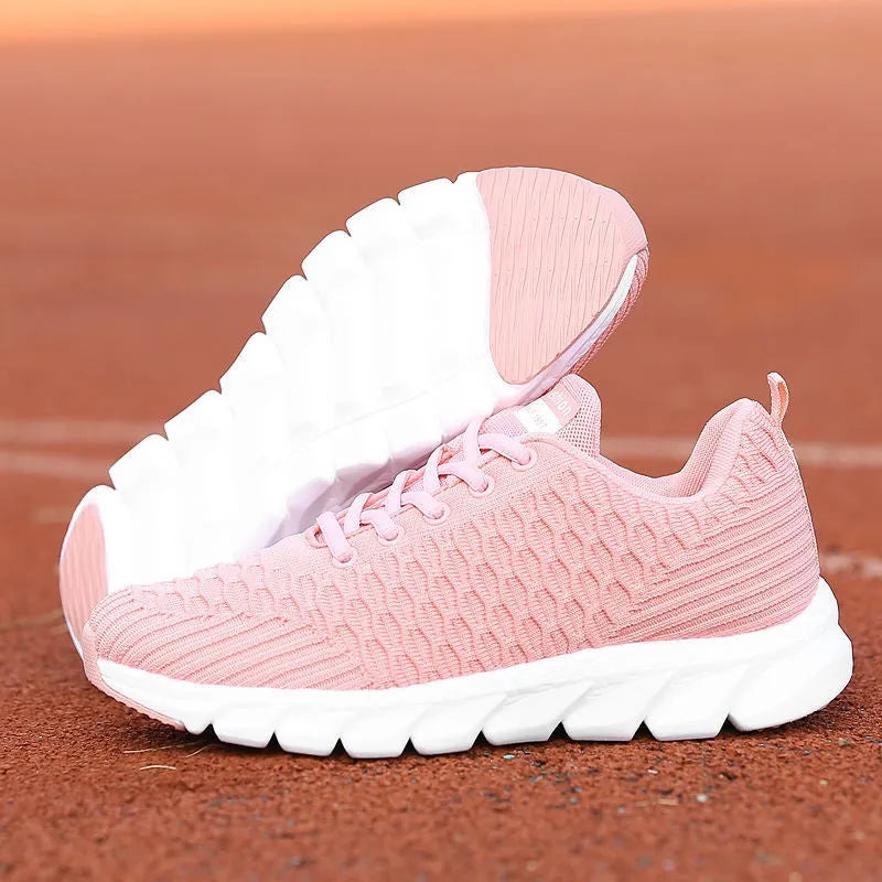 Women's running shoes in black, pink and white colours showing fly weave upper and durable outsole