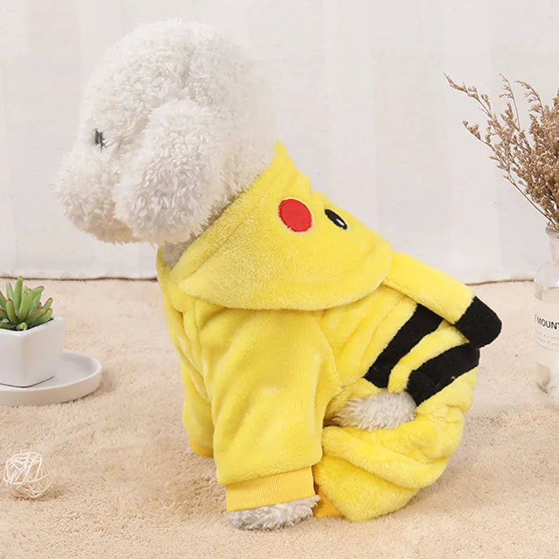 A small dog or cat wearing a cartoon-design fleece coat with a hoodie, suitable for indoor winter wear.