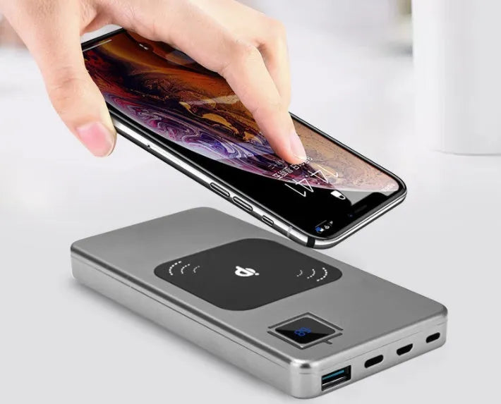 Silver alloy portable power bank with LCD display showing battery percentage, next to a smartphone.