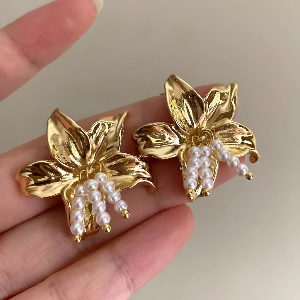 Gold H1795 flower earrings with exaggerated pearl accents on metal construction