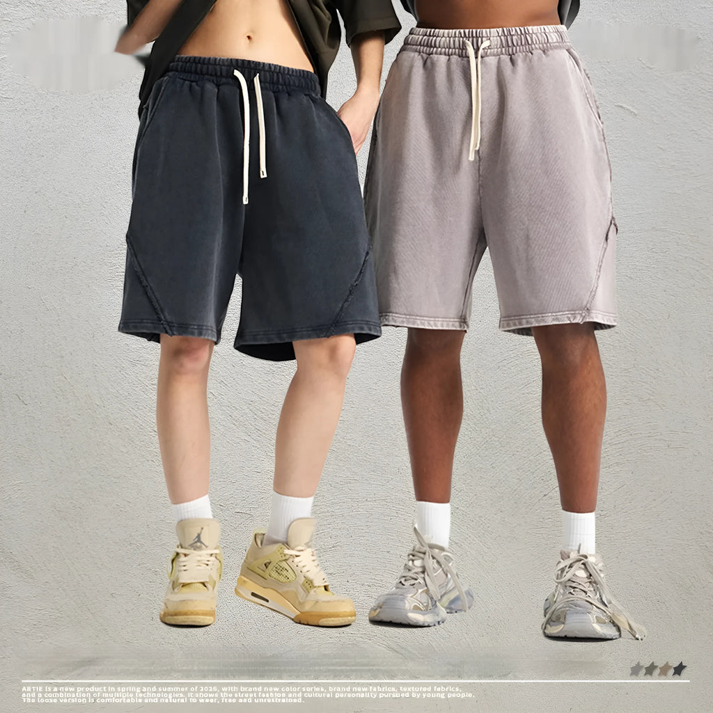 Men's loose black batik washed cotton shorts with patch craft design on a neutral background.