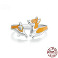 Silver corgi pet cartoon ring with electroplated colour on a model's finger.