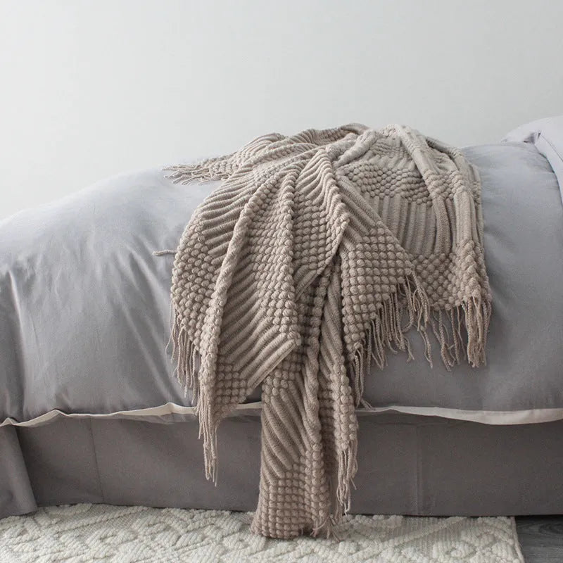 Small dark grey polyester nap blanket folded, showing its size of 127 cm by 170 cm.