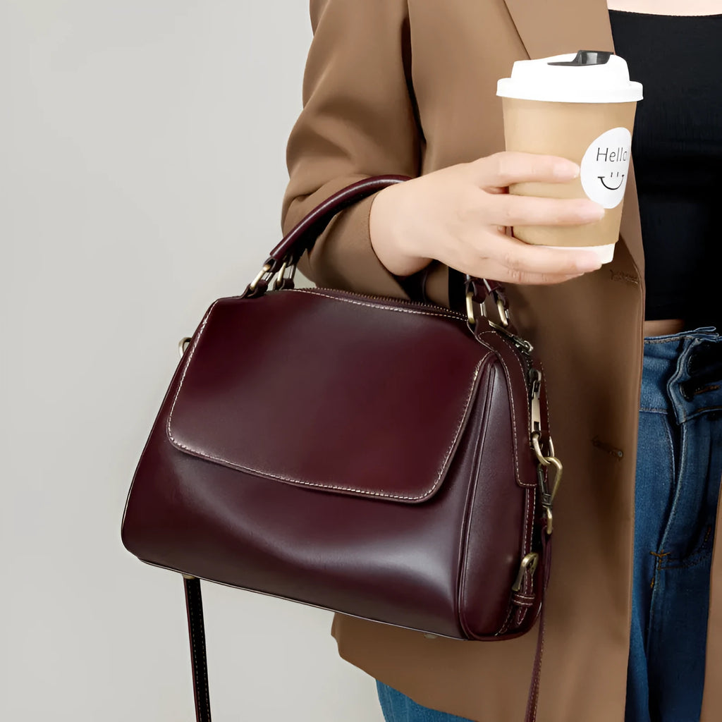 Women's soft cowhide leather crossbody tote bag in apricot colour, showing internal zip pockets and double shoulder strap.