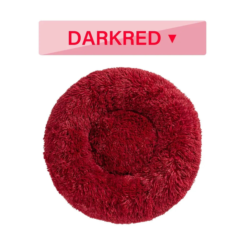 Fluffy donut-shaped dog bed in long plush fabric, shown in a light grey colour with a raised edge.