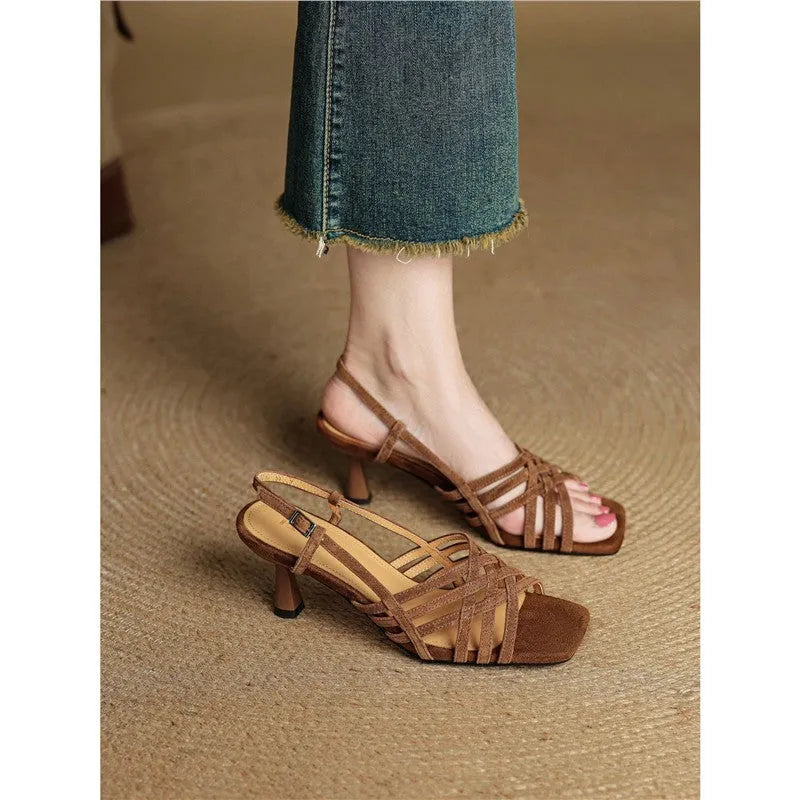 Retro women's sandals with thin cross straps, ankle buckle, and a mid heel on a square toe.