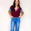 Burgundy women's loose V-neck sweater with white contrast trim and cuffed short sleeves