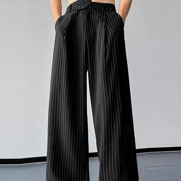 Men's black vertical striped pleated casual trousers showing elastic waistband and tapered leg