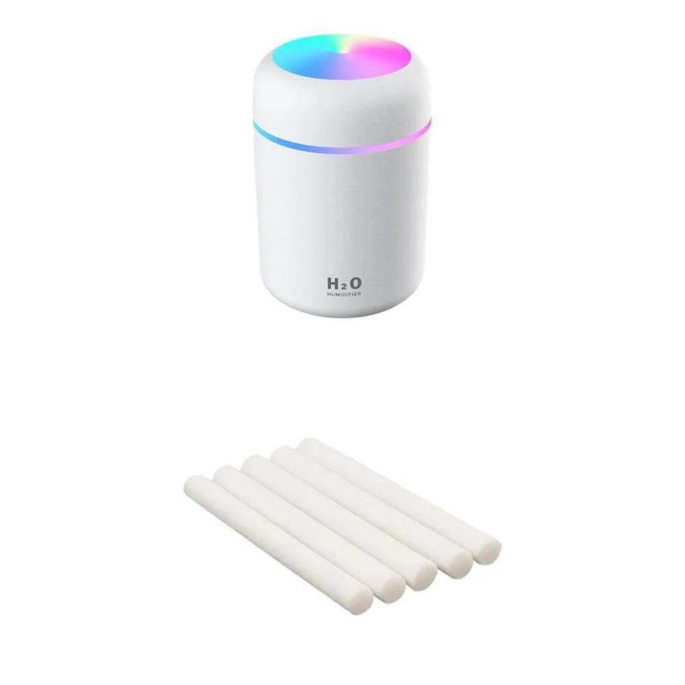 Pink USB desktop humidifier with coloured lights and water tank on a wooden desk