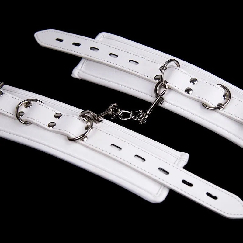 White PU sponge bondage set showing handcuffs, footcuffs, and a neck scarf laid out.
