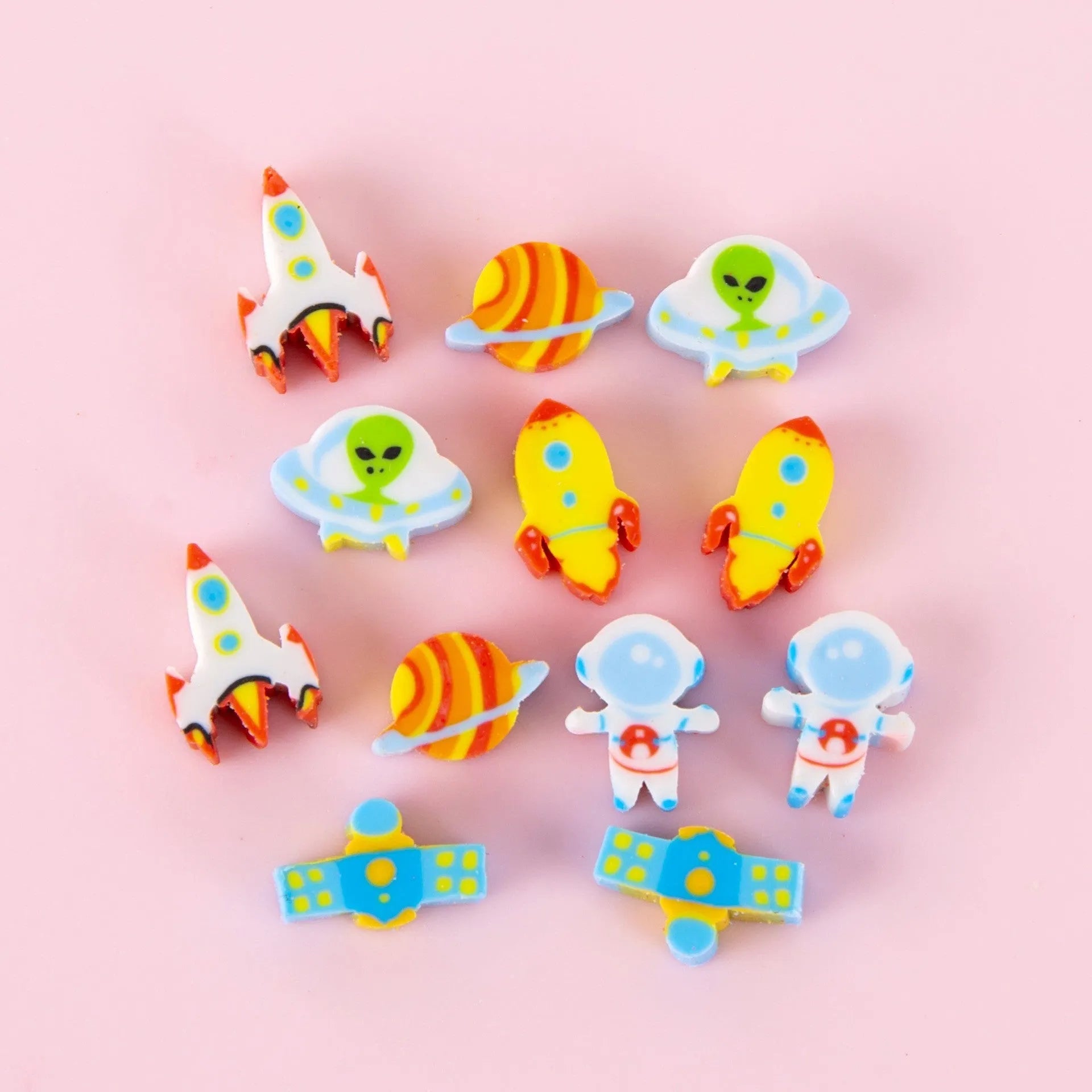 50 colourful cartoon mini erasers in shapes of fruits, animals, and cakes, displayed next to a pearlescent film bag.