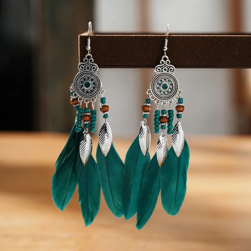 A pair of bohemian-style round drop earrings with a feather leaf pattern, shown in one of thirteen available colours.