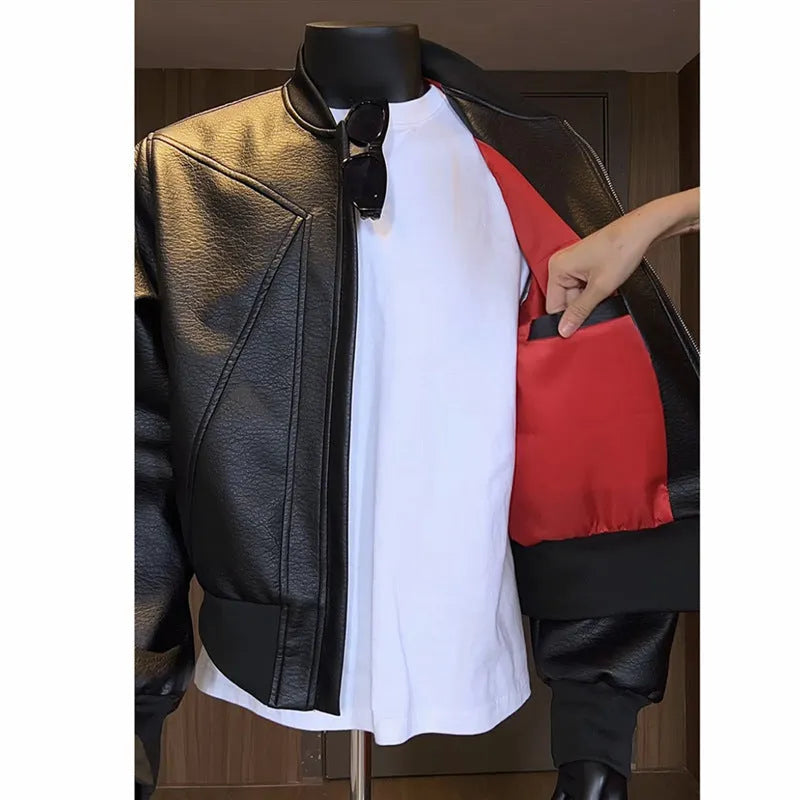 Man wearing a black slim-fit extended length PU leather jacket with a litchi pattern texture.