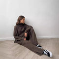 Women's acrylic suit set showing side-slit sweater top with matching trousers in solid colour