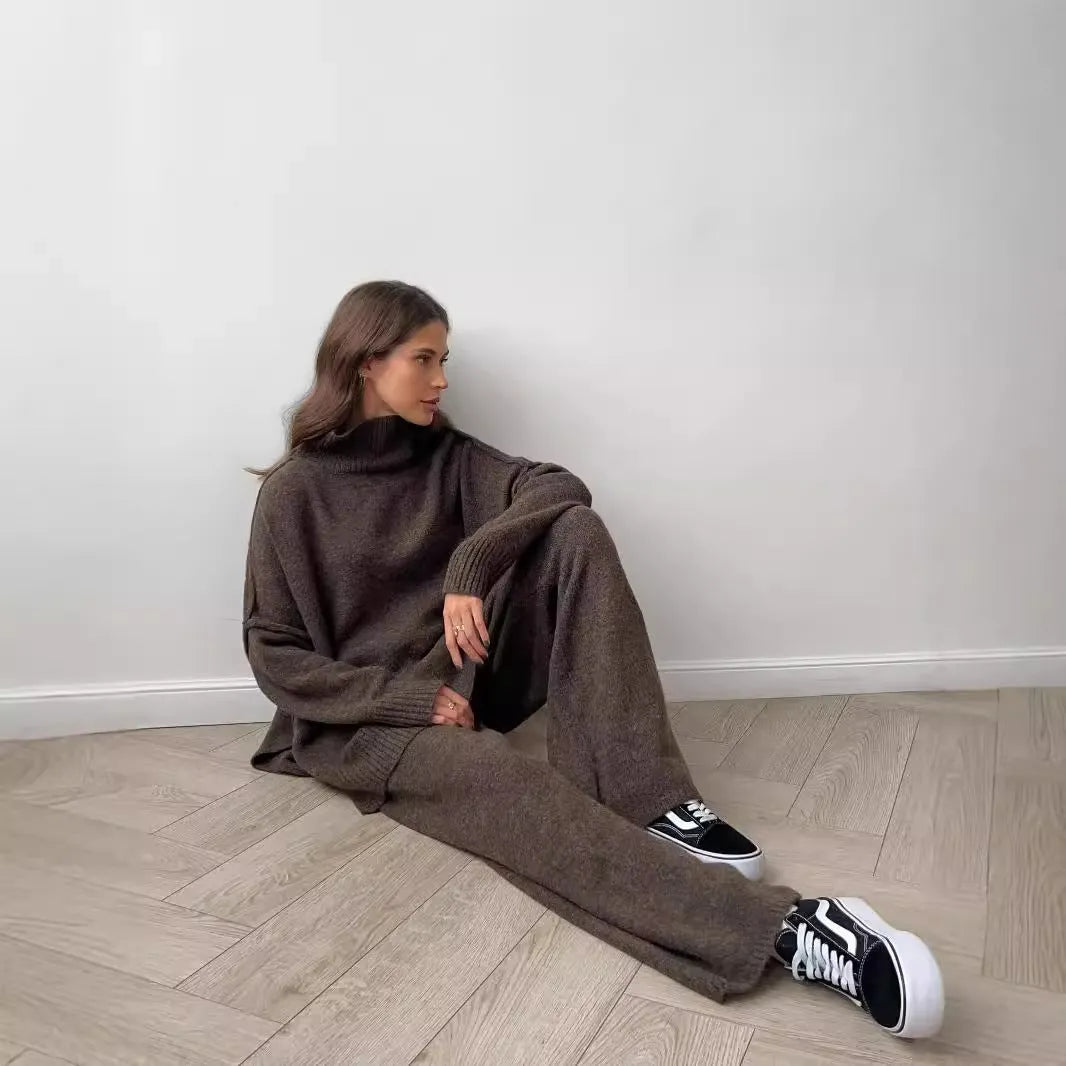 Women's acrylic suit set showing side-slit sweater top with matching trousers in solid colour