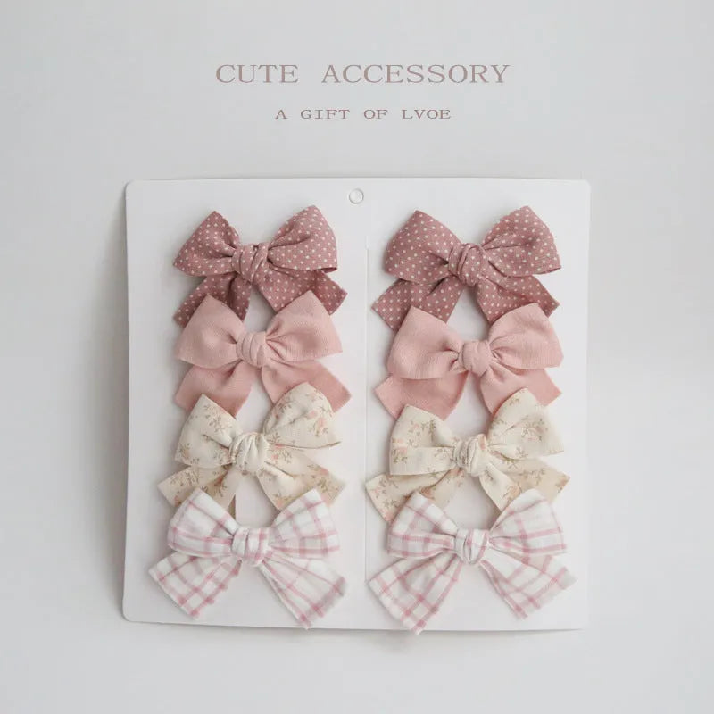 Children's fabric bow hairclips set showing dovetail design in multiple colour options