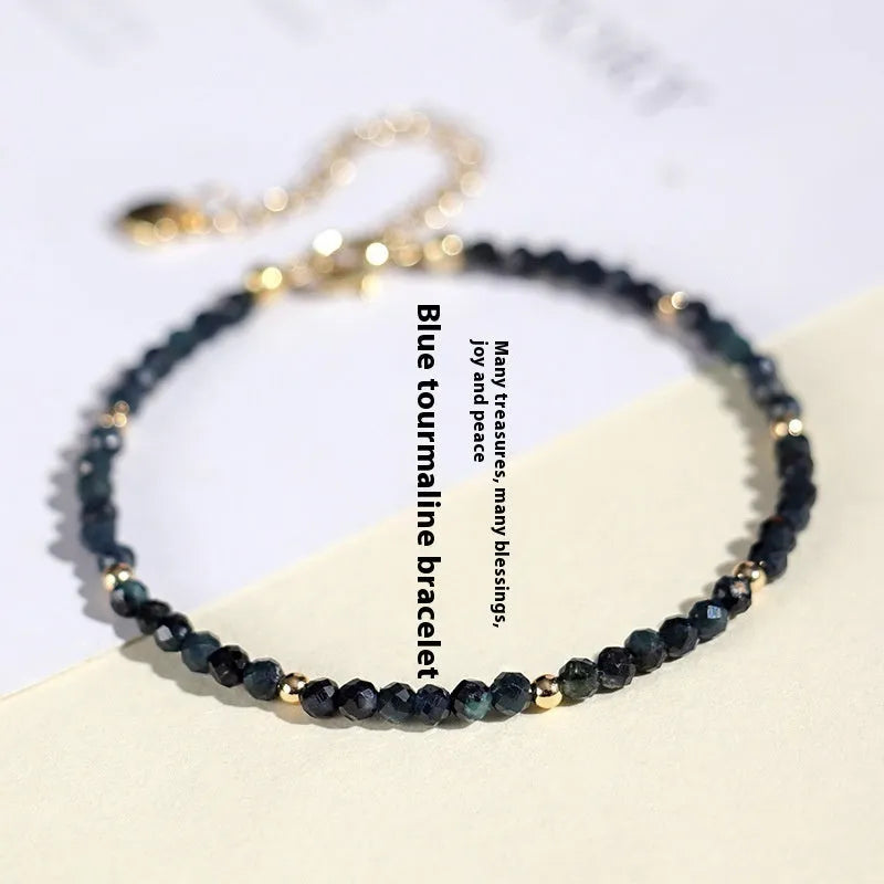 Close-up of a women's blue tourmaline gemstone beaded bracelet with 3mm beads and spacer design.