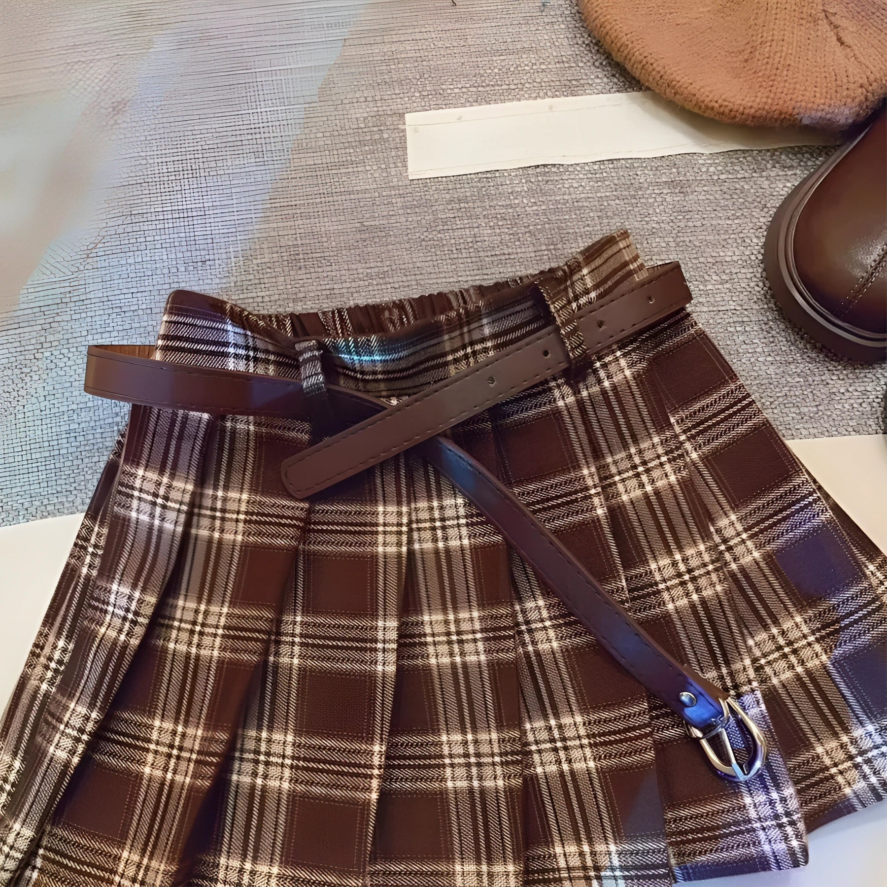 Girls' red and black plaid pleated A-line skirt on a hanger, showing cotton lining.