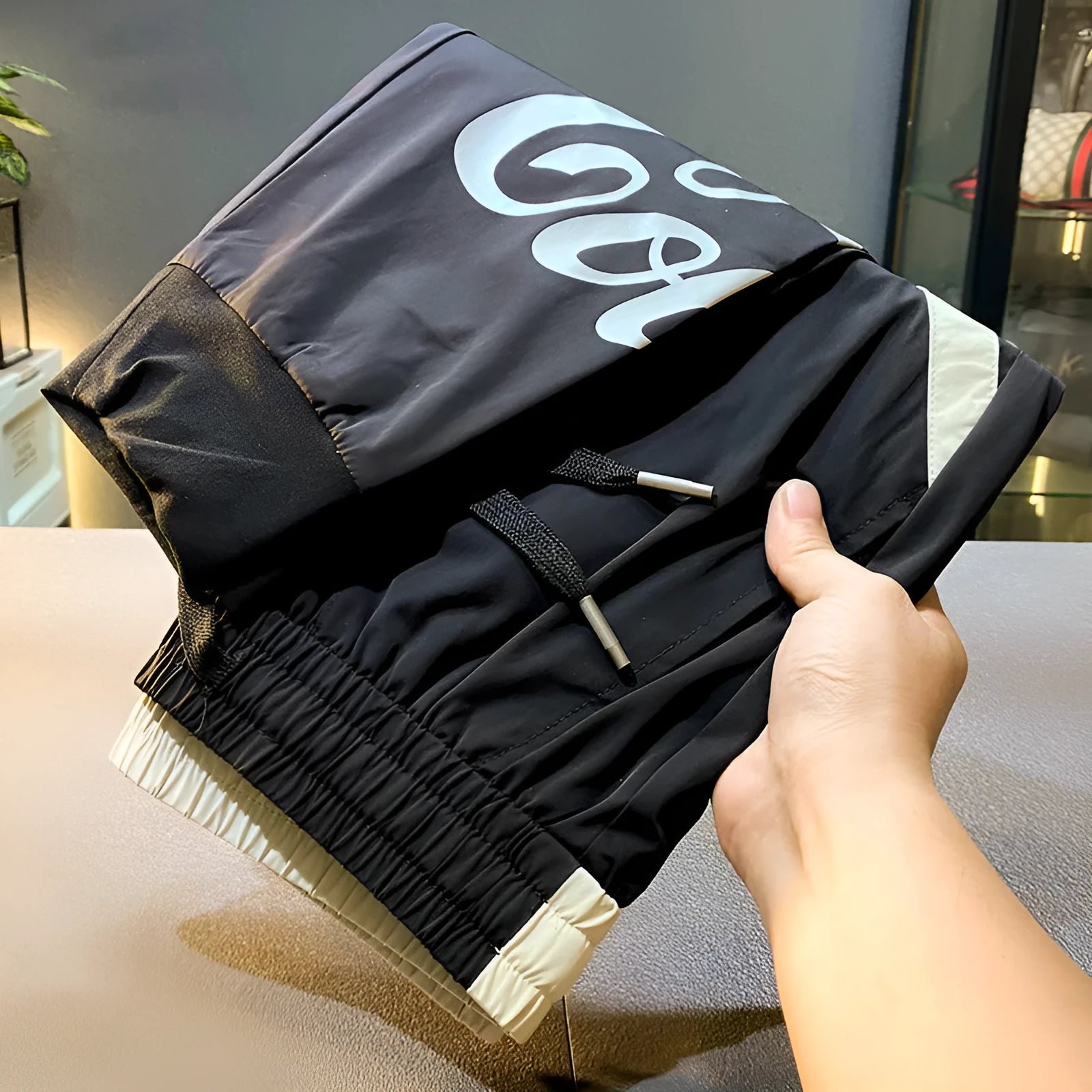 Men's black cropped trousers with ankle banding in ultra-thin ice silk fabric laid flat to show casual design.