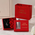 Red Korean style soap flower gift set with six roses in a box next to a matching handbag.