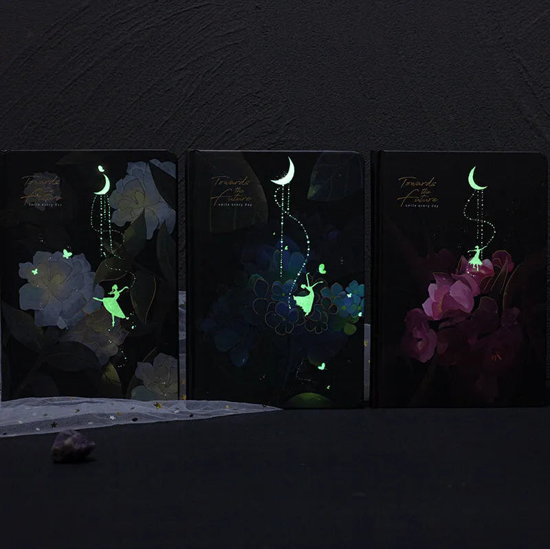 A5 spiral-bound notebook with a luminous holographic cover showing colour illustrations on the open pages.