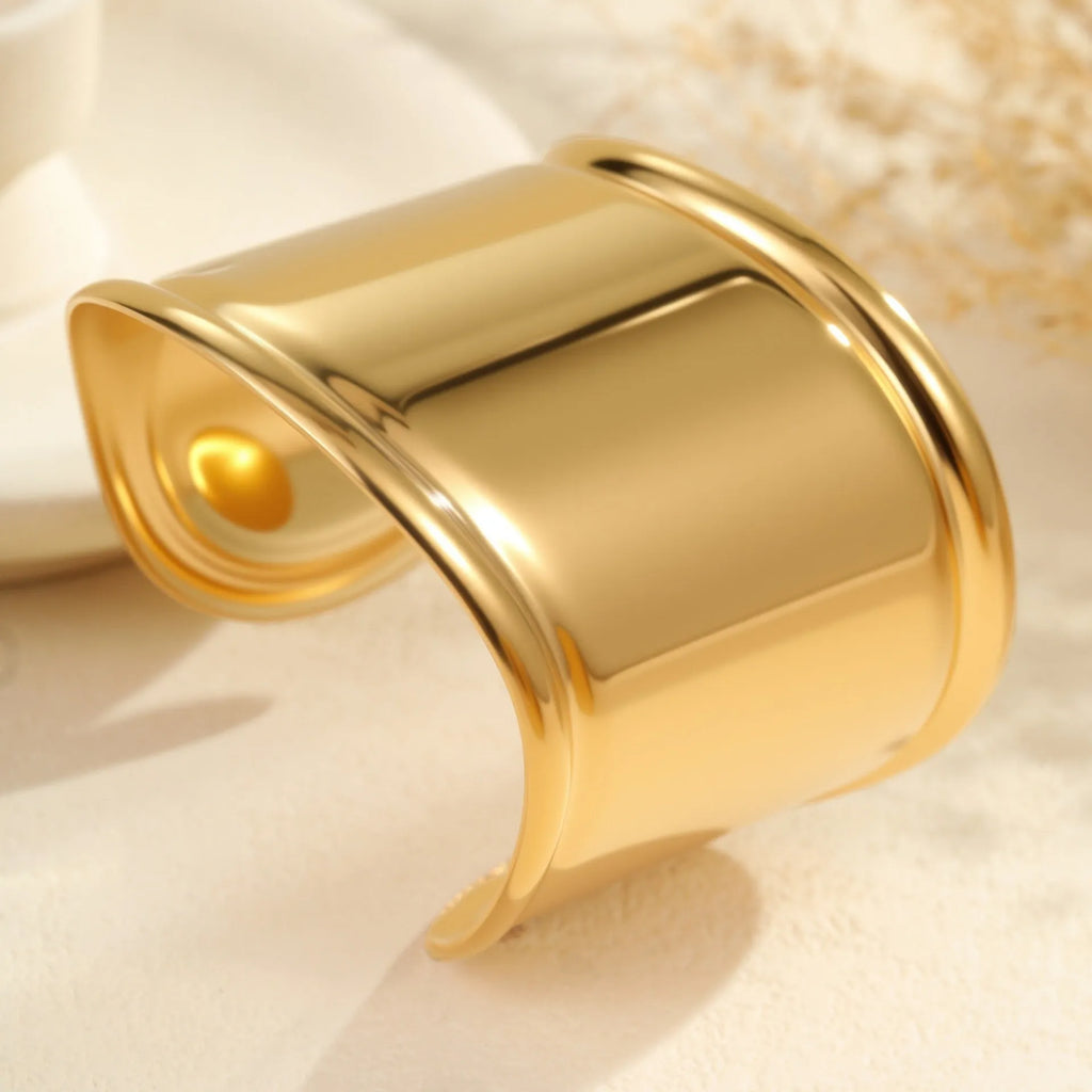 Women's exaggerated wide stainless steel bracelet with geometric wave design and niche opening in gold finish